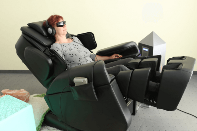 Seitenansicht: Frau benutzt Massagesessel im Brainlight-Studi im Businesspark Dresden